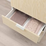 Open wooden drawer with fabric organizer and shirt inside, part of a storage system.