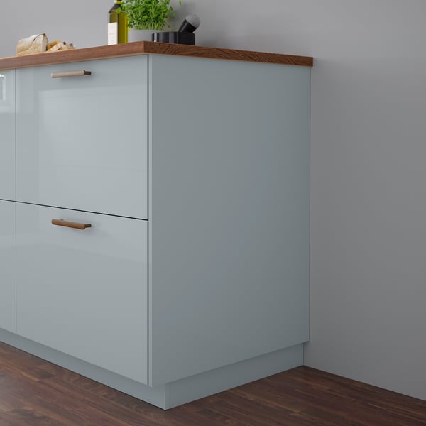 Light blue KALLARP cabinet, sleek & glossy, with wooden handles, small compared to wall.