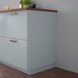 Light blue KALLARP cabinet, sleek & glossy, with wooden handles, small compared to wall.