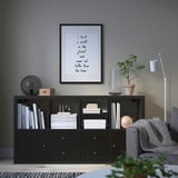 Cozy living room with KALLAX shelf, books, lamp, and plant.