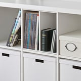 White KALLAX shelf unit with magazine and book inserts, and storage boxes.