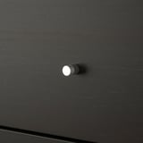 Close-up of a sleek, black KALLAX drawer handle; modern and minimalist design.
