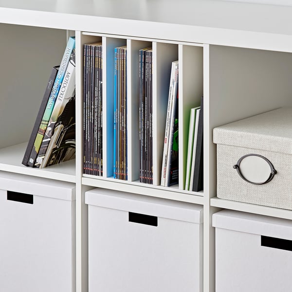 White KALLAX shelf with magazine/book organizer and storage boxes.