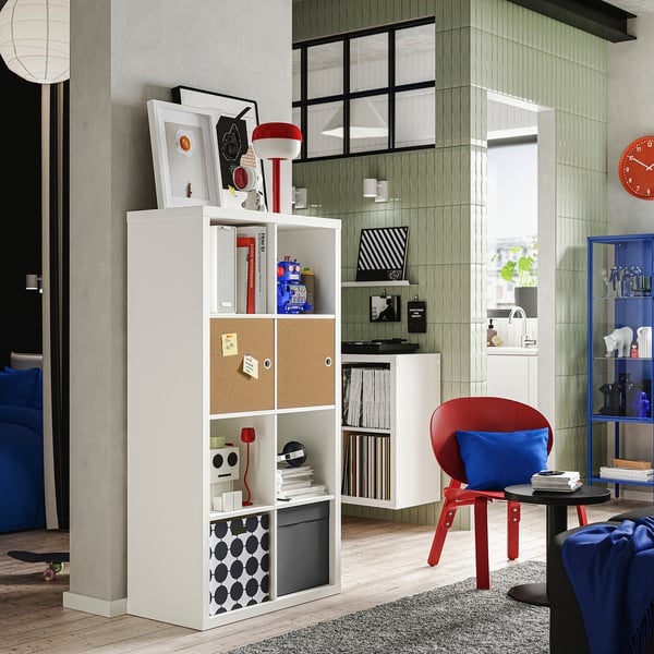 Modern KALLAX shelving with colorful items, cork door, and vibrant decor.