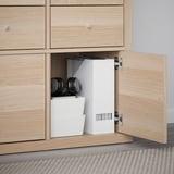 Light wood cabinet open with KALLAX shelves and white storage bins, showing home organization.