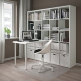 Modern KALLAX desk with open/closed storage, chair, laptop, plant.
