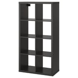 A black KALLAX bookshelf with multiple open compartments, made of particle board and acrylic paint, designed for versatile storage.