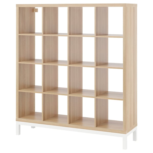 A KALLAX wooden bookshelf in light finish with white legs, featuring a grid of square compartments.