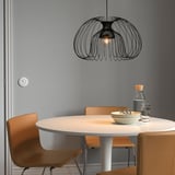 Modern dining setup with round wooden table, orange chairs, and KALLFRONT lamp.