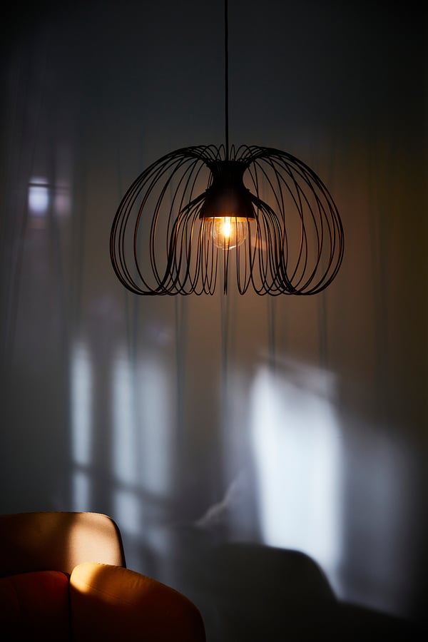 Modern hanging lamp, KALLFRONT, black, wire mesh, globe shape, casting shadows, warm light.
