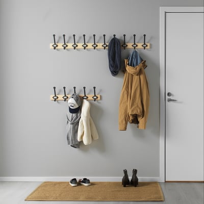KARTOTEK coat hooks organize entryway. Light wood, black hooks. Hangs jackets, bags near door. Small, holds items neatly.