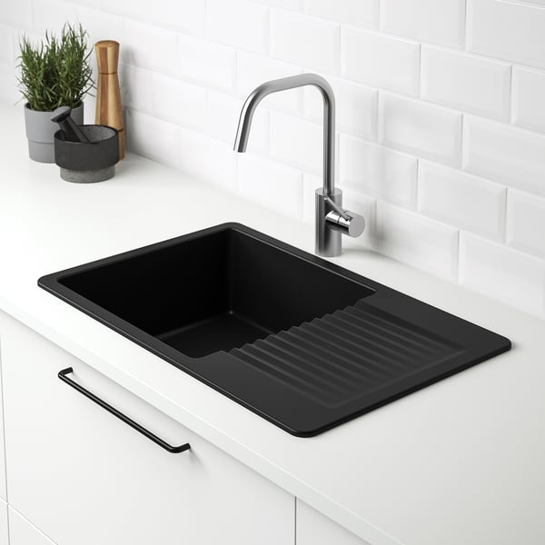 Black quartz sink with drainboard, integrated faucet, white countertop.