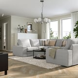 Modern living room with KIVIK sectional, rug, coffee table, and chandelier.