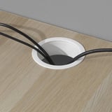 Cable management hole in wooden desk keeps wires tidy and organized.