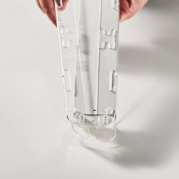 Hand holding adjustable fridge organizer.