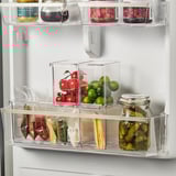 Fridge organizers store fruits, veggies, and pickles, maximizing space with clear, stackable boxes for easy access.