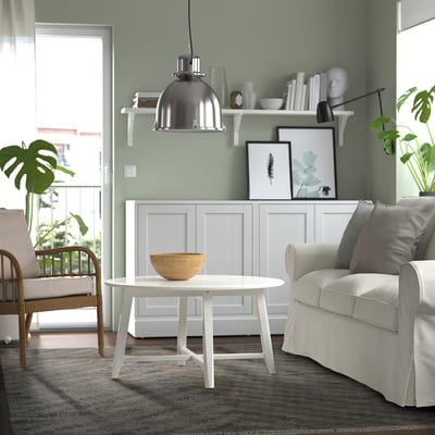 Modern living room with KNAPPHIRS rug, grey couch, and green walls.