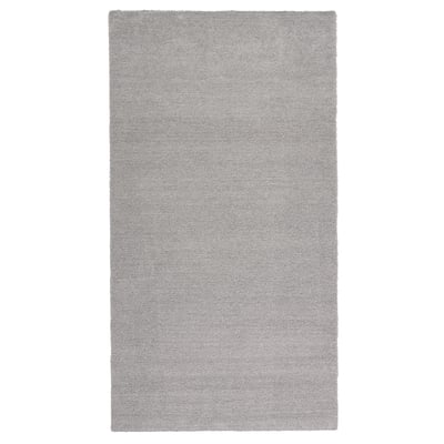 A light grey, rectangular rug with a sheen, made from recycled polyester, featuring a soft, thick pile.