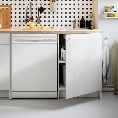 Kitchen scene with open dishwasher and countertop items.