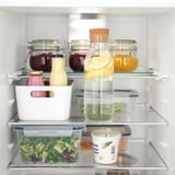 Organized fridge with adjustable shelves holding beverages and fresh foods.