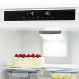 Modern fridge with digital controls and led light. White cheesecake with raspberries, plastic containers shown. Temperature displays at 4°c and -16°c.