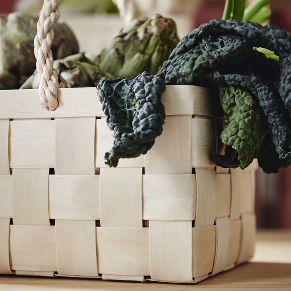 Handwoven basket holds fresh vegetables, quality craftsmanship.