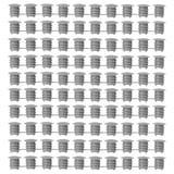 Grid of gray KOMPLEMENT polyethylene plastic cover caps, uniformly arranged, cylindrical shape with ridged design.