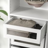 Glass-front drawer with folded clothes, part of KOMPLEMENT series.