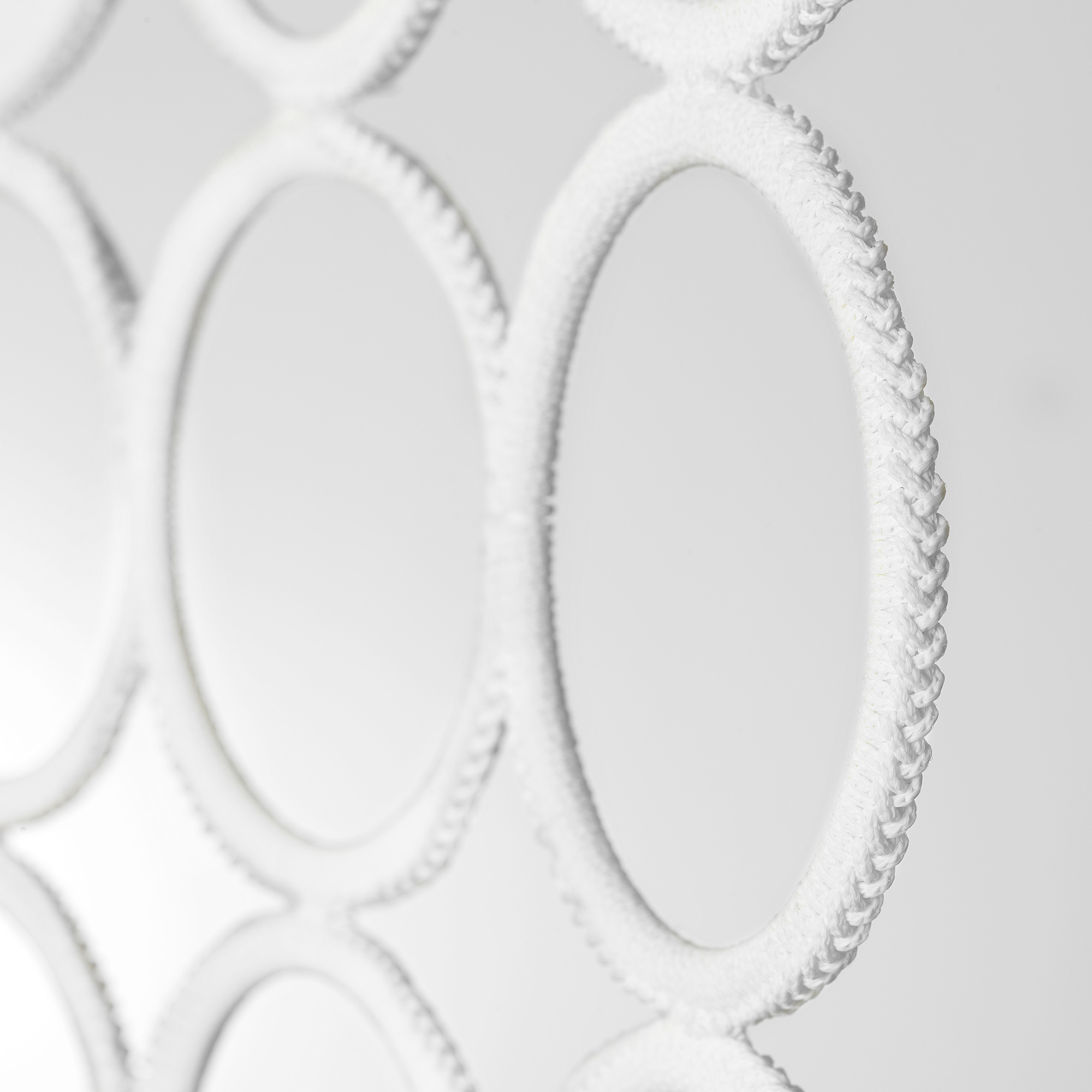 KOMPLEMENT hanger close-up, showcasing intricate design and durable materials with braided loops.
