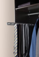 KOMPLEMENT black closet organizer holds ties on metal rod, black background.