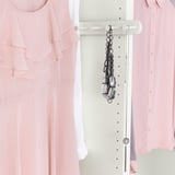 Accessories hanger with five hooks hanging necklaces and a bracelet.