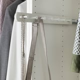 White wardrobe organizer with hooks hanging belts and jewelry.