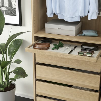 Wooden dresser with pull-out drawer for accessories, clothes, and a plant.