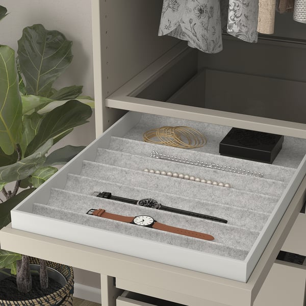Pull-out jewelry tray with compartments, displaying watches, necklaces, and bracelets on felt-lined shelves.