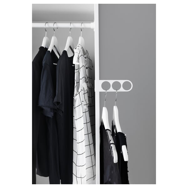Black and white a wardrobe with KOMPLEMENT valet hanger holding dark clothes.