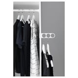 Black and white a wardrobe with KOMPLEMENT valet hanger holding dark clothes.