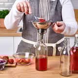 Straining fruit juice with stainless tool.