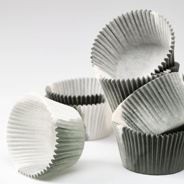 Irregular pile of folded paper baking cups, crumpled for aesthetic appeal, in neutral tones.