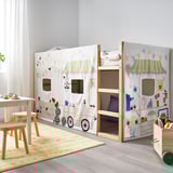 Playful kids room with a white KURA bunk bed featuring a market stall-themed, eco-friendly curtain. Bright and imaginative design, promoting play.