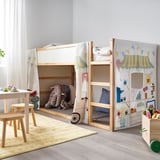 KURA bed with whimsical market stall curtains in pastels, featuring a playful design. Kids room includes wooden furniture and toys.
