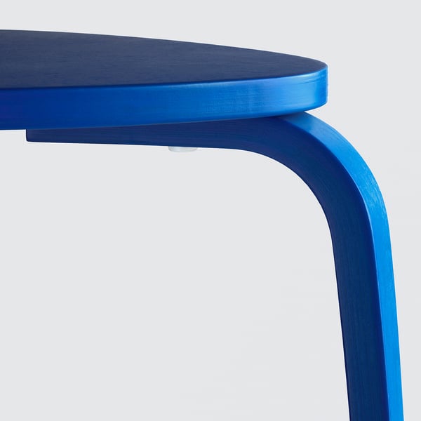 Close-up of a vibrant blue, finely crafted wooden stool, showcasing sleek design and durable finish.