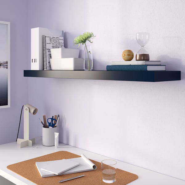 Modern white desk with bLACK shelf, books, green vase, lamp, and stationery. Includes cork mat, notebooks, and water glass.