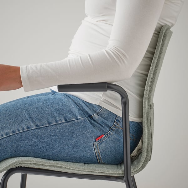 A person sitting in a LÄKTARE conference chair with armrests providing support.