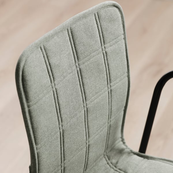 Close-up of a chairs backrest, showcasing its high-quality, evenly stitched upholstered fabric, affixed to a robust metal framework.