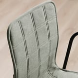 Close-up of a chairs backrest, showcasing its high-quality, evenly stitched upholstered fabric, affixed to a robust metal framework.
