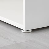 White adjustable furniture foot on gray floor.