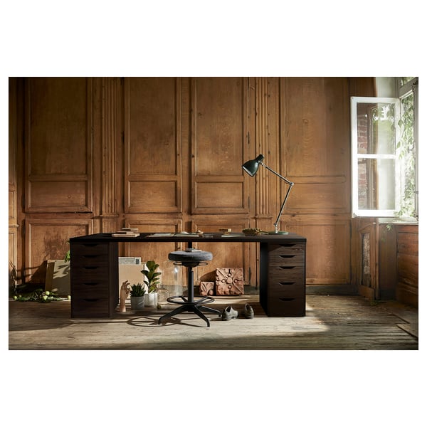 Modern home office setup with LAGKAPTEN black-brown desk, wooden panels, window, lamp, chair, and plants.