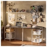 LAGKAPTEN desk with storage, laptop, books, notes, and decor.