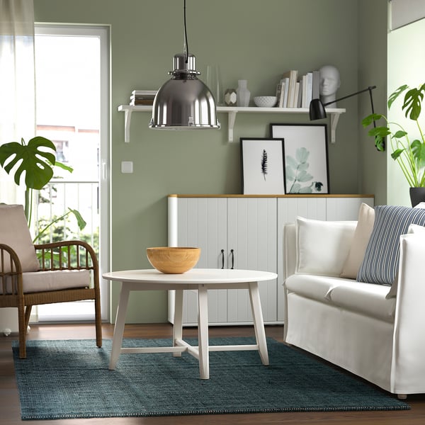 Living room with LANDBANA jute rug, coffee table, chair, couch, green walls.