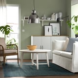 Living room with LANDBANA jute rug, coffee table, chair, couch, green walls.